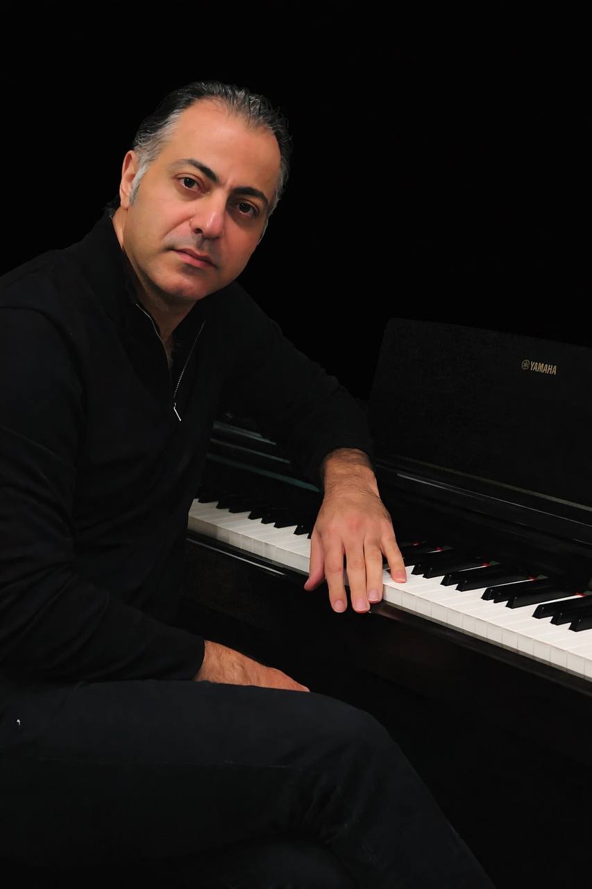 Ali seated at a piano
